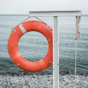orange lifebuoy on the sea coast